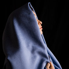 Woman covered with a dark covering shawl