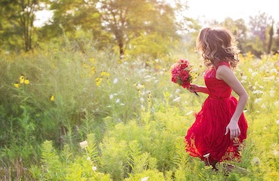 Little girl running in a garden holding flowers and free