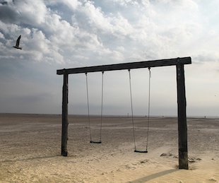 Empty swing set on a beach